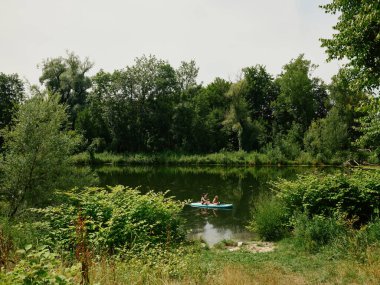 Turistler, Augsburg 'daki Wertach nehrinde kano yapıyorlar.