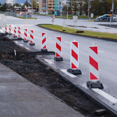 A road with red and white striped signs
