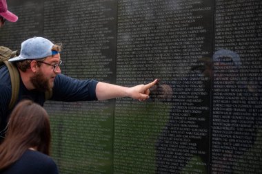 Washington, DC 'deki Vietnam Anıtı' nda bir adamı işaret ediyor.