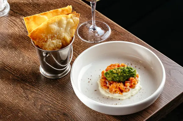 trout tartare with sauce and a glass of wine