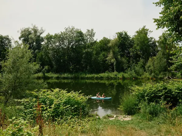 Turistler, Augsburg 'daki Wertach nehrinde kano yapıyorlar.
