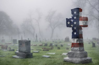 Sisli bir günde mezarlıkta Amerikan bayrağı haçı, vatanseverlik, inanç ve anma sembolü.