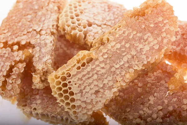 白い背景に液体の蜂蜜で満たされたハニカムの破片 — ストック写真