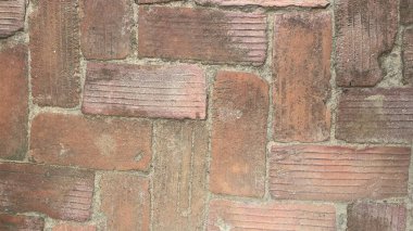 Kırmızı tuğla zeminin üst görüntüsü desen, doku ve doğal aşınmayı gösteriyor..