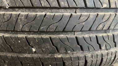 Yıpranmış bir lastik yüzeyine yakın çekim, dokusunu renklendirir ve aşınır..