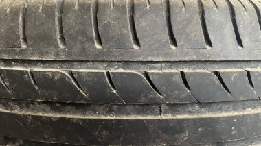 Yıpranmış bir lastik yüzeyine yakın çekim, dokusunu renklendirir ve aşınır..