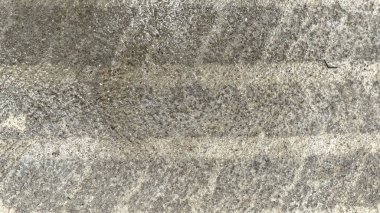 Sert beton zeminde siyah lastik fren izleri var.