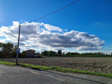evocative image of a group of clouds in an Italian countrysideat the bus stop