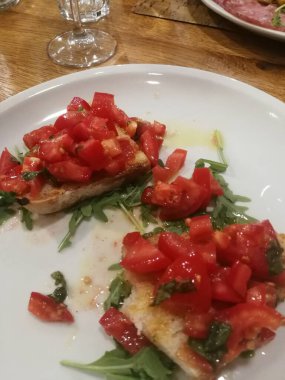 close up of a plate of bruschetta platter with tomatoes, basil, oil and garlic
