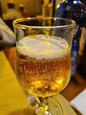 evocative close-up image of a glass of beerin a pizzeria