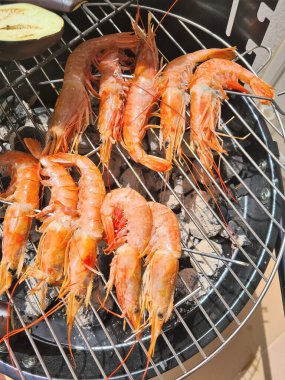 evocative close-up image of king prawns on the BBQ grill ready to be cooked