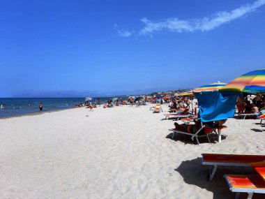 Yazın Sicilya 'da kumlu bir kumsalın güzel mavi bir gökyüzünün altında canlandırıcı bir görüntüsü. 