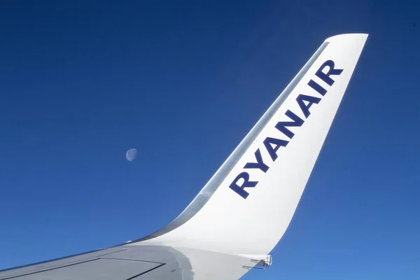 stock image 2022.02.21 Palermo Punta Raisi Airport, Ryanair low cost airlineevocative image of the plane's wing in flight with the sky and the fullmoon in the background