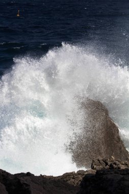 evocative image of a rough sea hitting the rocks in Sicily