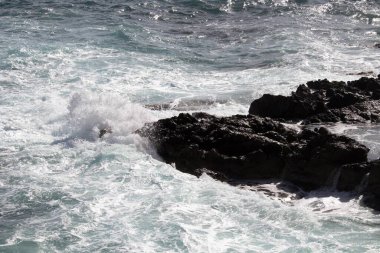 evocative image of a rough sea hitting the rocks in Sicily