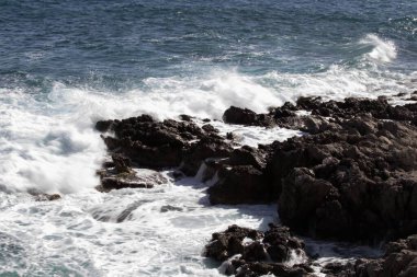 evocative image of a rough sea hitting the rocks in Sicily
