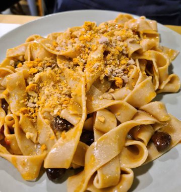 Bir İtalyan restoranındaki taze makarna tabağının canlandırıcı görüntüsü.