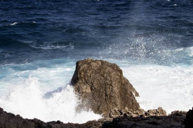 evocative image of a rough sea hitting the rocks in Sicily