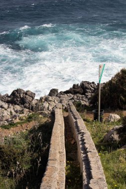 evocative image of a rough sea hitting the rocks in Sicily