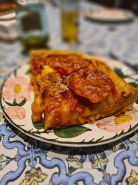 İtalyan yapımı ev yapımı domates, mozzarella, biber ve baharatlı salamdan oluşan kare bir pizzanın canlandırıcı görüntüsü.