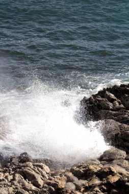 evocative image of a rough sea hitting the rocks in Sicily