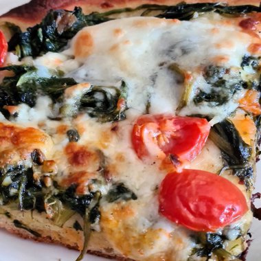 Friarielli, domatessiz, domatessiz, mozzarellalı ve füme scamorzalı beyaz pizzanın anımsatıcı yakın plan görüntüsü.