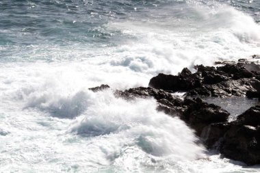 evocative image of a rough sea hitting the rocks in Sicily
