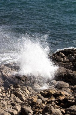 evocative image of a rough sea hitting the rocks in Sicily