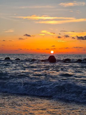 Güzel bir günde sakin denizin üzerinde gün batımını anımsatan bir görüntü.