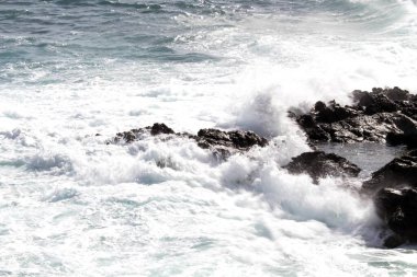 evocative image of a rough sea hitting the rocks in Sicily