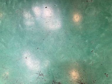 Eski, parlak, yeşil beton bir zemin. Üzerinde siyah çizikler ve sıcak renkli ışıklar var. Arka plan olarak kullanılıyor.