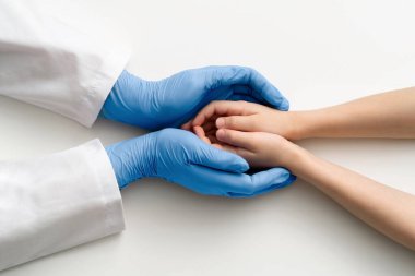 Doktorların elleri eldivenliydi, çocuklarının ellerini tutuyorlardı. Üst Manzara. Tıbbi konsept.