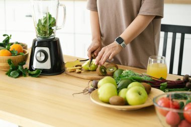 Mutfaktaki yeşil buzlu içecekten kahvaltı hazırlayan kadını kapat, kapat. Mutfaktaki masada doğal detoks limonatası hazırlıyorum.