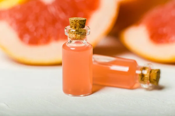Orange essential oil in bottles, grapefruits, oranges on background close-up. Natural medicine concept, aromatherapy