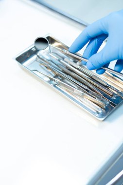 Diş aletlerini seçerken dişçiye yakın dur. Eldeki diş aletleri. 