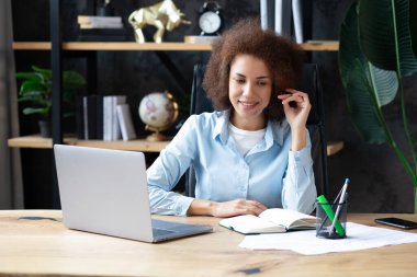 Çağrı merkezinde çalışan müşteri hizmetlerinden bir kadının portresi. Ofiste kulaklıkla çalışan gülümseyen Amerikalı müşteri hizmetleri temsilcisi. 