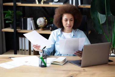 Kendine güvenen Afrikalı Amerikalı İş kadını İş yerindeki Kameraya Gülümsüyor.