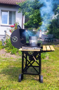 Bir evin arka bahçesinde barbekü yapmak.