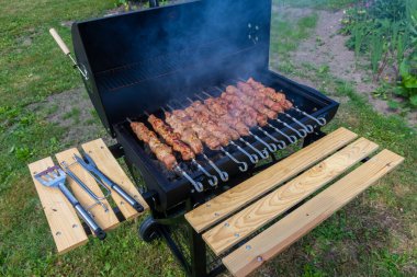 B-B-Q. Evin arka bahçesinde barbekü yapıyor.