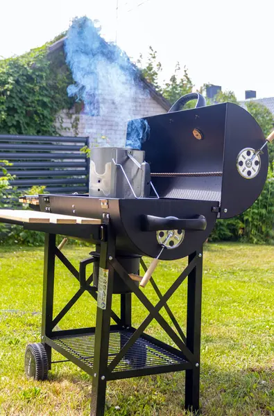 Bir evin arka bahçesinde barbekü yapmak.