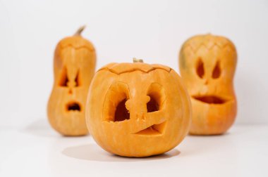 Beyaz arka planda üç tane Jack-o-Lantern. Cadılar Bayramı dekorasyonu