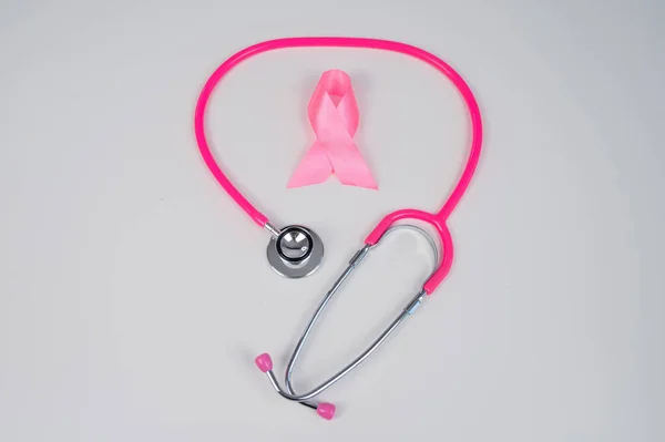 stock image Pink ribbon and stethoscope on a white background. The concept of the fight against breast cancer