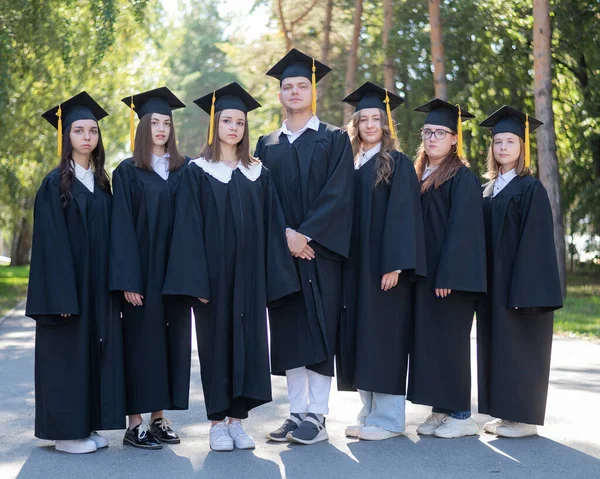 Sieben Absolventen Roben Stehen Einer Reihe Freien — Stockfoto