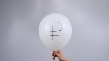 Avro sembollü sönmüş beyaz bir balon tutan bir kadın var.