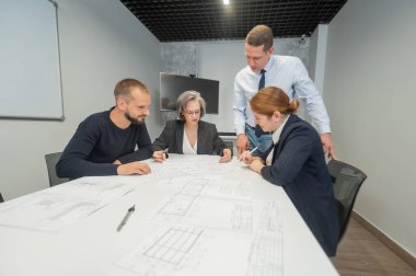 Dört meslektaşı bir ofisteki konferans odasının planlarını tartışıyor. Mühendis ve mimarların beyin fırtınası