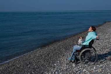 Tekerlekli sandalyedeki mutlu kadın elini kaldırdı ve uçtuğunu hayal etti.