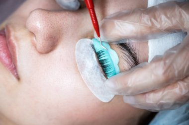 Usta kirpikleri kaplamak için çok fonksiyonlu bir araç kullanır