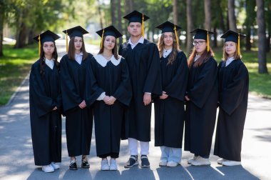 Cüppeli yedi mezun açık havada sıraya dizildi.