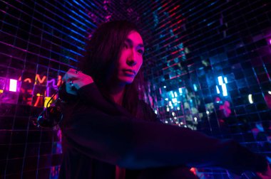 Asyalı adam güneş gözlüğü tutuyor. Neon fotoğraf stüdyosu