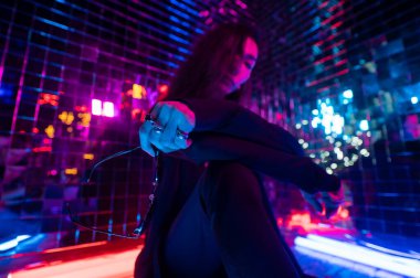 Asyalı adam güneş gözlüğü tutuyor. Neon fotoğraf stüdyosu